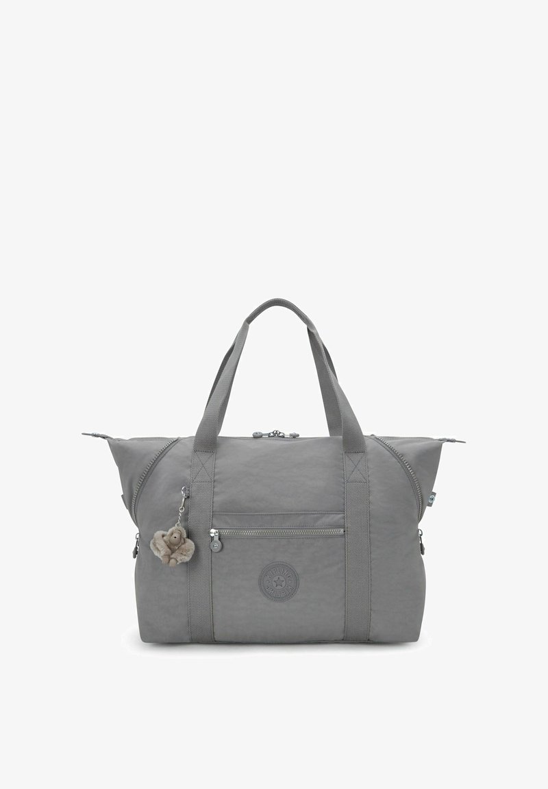 Sac de sport gris en nylon doux. Il possède des poignées jumelées, une poche frontale zippée et un charme décoratif en porte-clés.