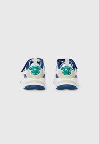Zapatillas azules y blancas con acentos beige, materiales de tela y goma, logotipo verde notable en el talón, suela acolchada y diseño sin cordones.