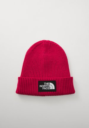Fuchsia knitted beanie with a ribbed design and a fold-over cuff. Features a black label with white text and logo from The North Face.
