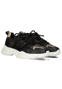 Zwarte en beige atletische sneakers van mesh en suede materiaal. Dikke witte rubberen zool met ingewikkelde stiksels en veterdetails.
