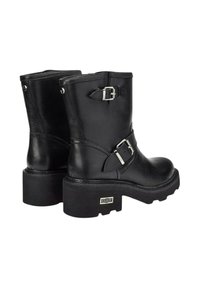 Stivali neri in pelle fino alla caviglia con suola nera spessa, fibbie laterali e dettagli in metallo argentato. Texture liscia con dettagli di cucitura.