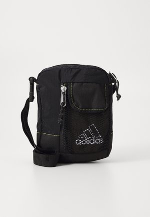 Schwarze Adidas-Umhängetasche mit Fronttasche aus Mesh, Reißverschluss und verstellbarem Riemen, mit weiß gesticktem Adidas-Logo.