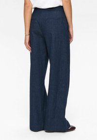 Dark blue, wide-leg denim trousers with a smooth texture and two back pockets. Features a high waistband and a straight cut to the hem.