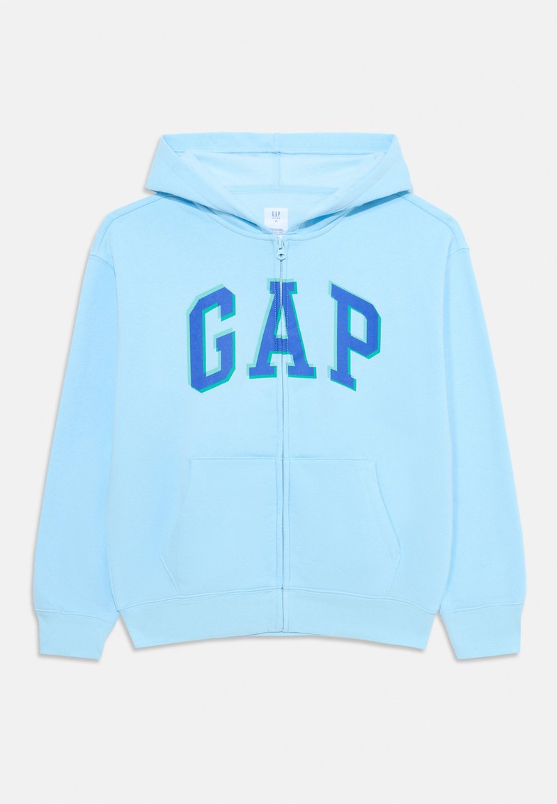 Felpa blu chiaro con zip realizzata in tessuto morbido, caratterizzata da un grande logo "GAP" in tonalità più scure di blu, con due tasche frontali e cappuccio con cordino.