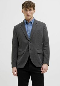 Grau strukturierter Blazer mit Reverskragen, einreihiger Knopfverschluss, zwei Vorderpockets und einem Denimhemd darunter.