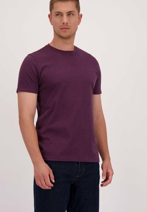 Paarse T-shirt met korte mouwen, gemaakt van zachte katoenstof, met een ronde halslijn en een ontspannen pasvorm. Gecombineerd met donkerblauwe jeans.