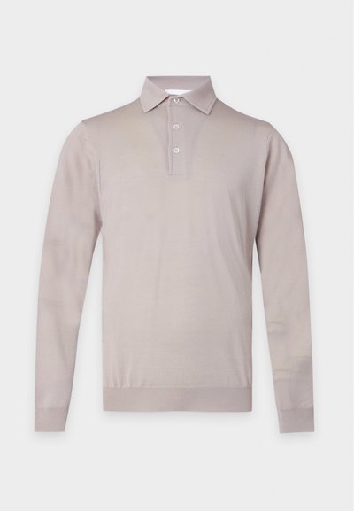 Polo beige à manches longues avec trois boutons et ourlet et poignets côtelés sur un fond uni.