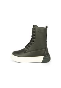 Stivale alla caviglia in pelle nera con suola in gomma bianca, punta rotonda e otto fori per i lacci. Presenta una linguetta sul retro e una superficie texture.