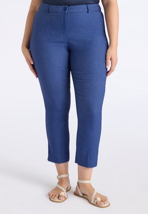 Pantalons capri en denim bleu foncé avec une silhouette ajustée, dotés d'une fermeture à bouton, de poches latérales et de détails de couture visibles.