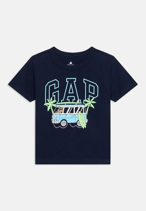 Granatowy dziecięcy t-shirt z jasnoniebieskimi literami GAP, palmami, niebieskim vanem z kierowcą niedźwiedziem i zieloną deską surfingową z przodu.