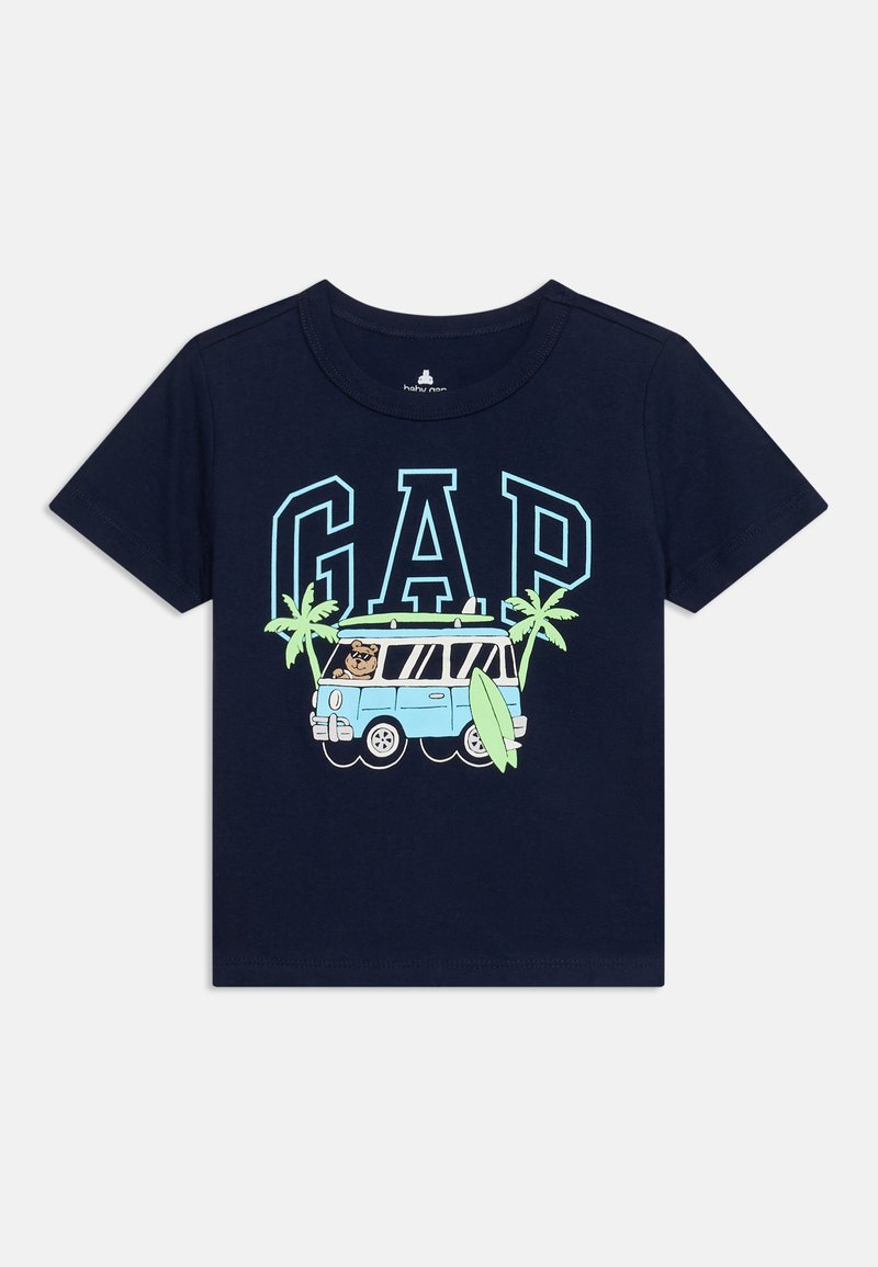 T-shirt enfant bleu marine avec lettres GAP bleu clair, palmiers, un van bleu avec un conducteur ours et une planche de surf verte à l'avant.