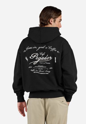 Black hoodie with a large white graphic on the back featuring text about a café. Soft fabric, loose fit, ribbed cuffs and hem.