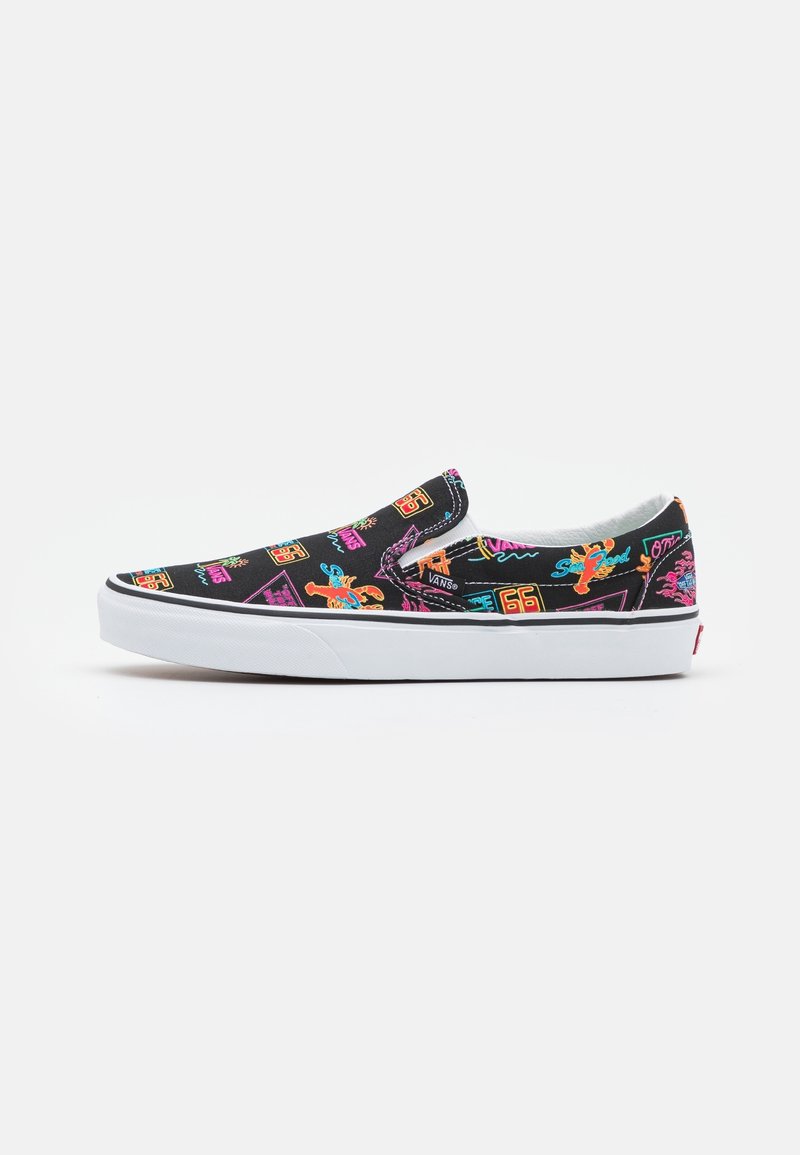 Basket slip-on Vans noire avec des graphismes rétro colorés et une semelle en caoutchouc blanche, vue de côté sur un fond blanc.