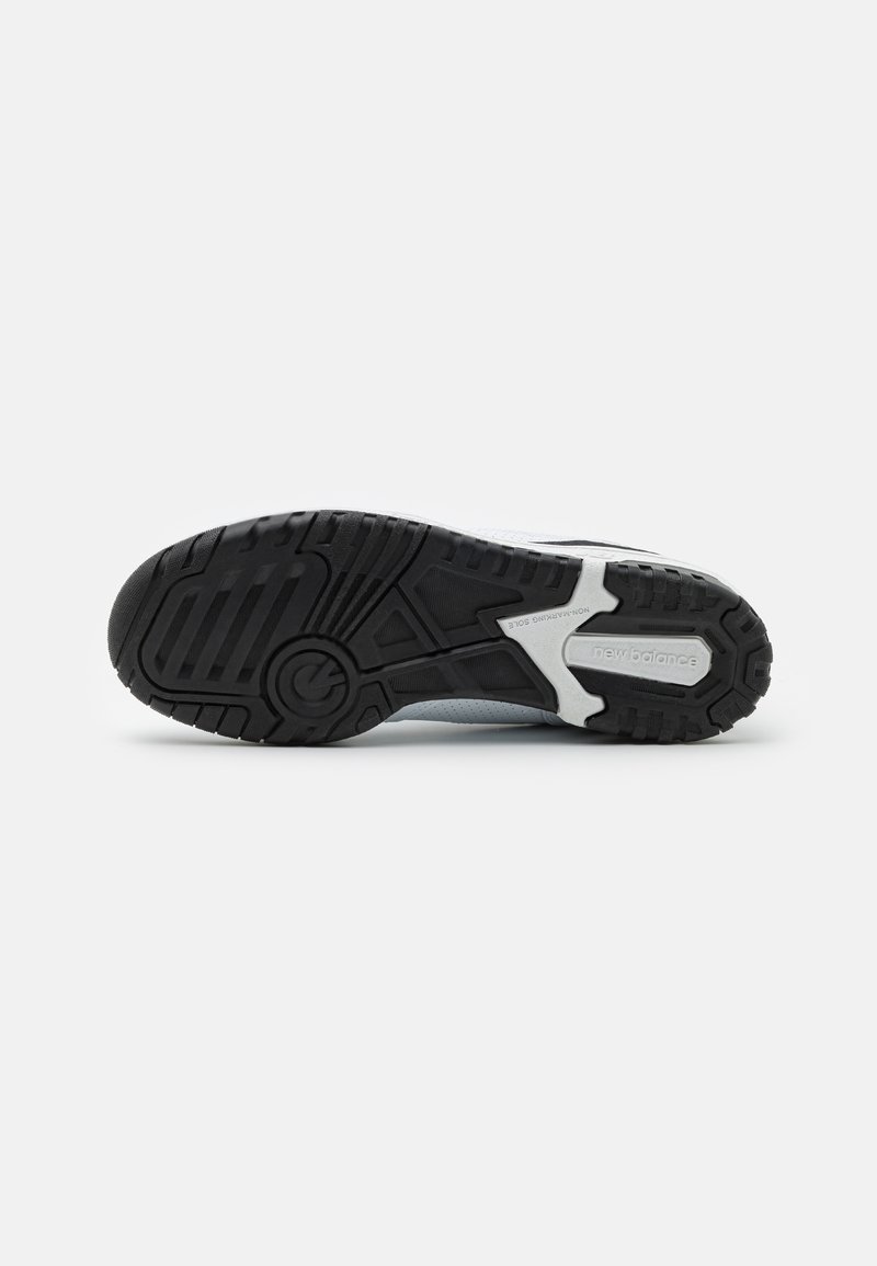 Suela de zapatilla deportiva en negro y gris con un patrón texturizado y diseño de suela. Presenta una entresuela blanca con detalles de marca y una suela exterior de goma duradera.
