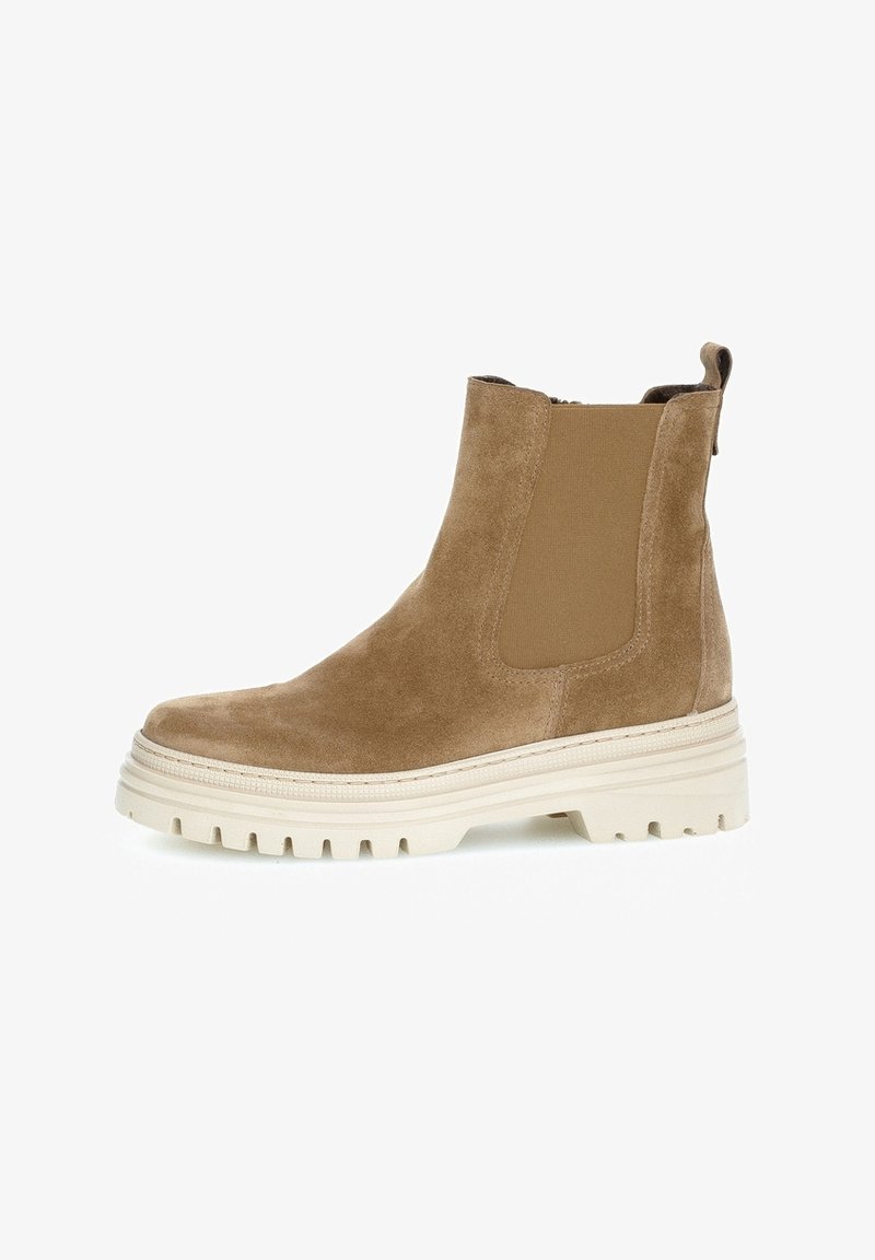 Botte Chelsea en daim fauve avec panneau latéral élastique, languette à l'arrière, et semelle épaisse en caoutchouc blanc à crampons profonds.