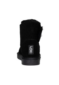 Stivaletto in suede nero con una morbida fodera in pelliccia, suola piatta in gomma e etichetta G sul lato esterno; tacco arrotondato, dettagli di cucitura minimi.
