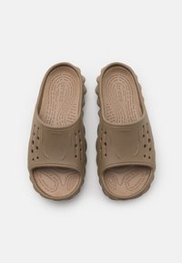 Brown Crocs slide sandals with a smooth, textured upper, open-toe design, and perforations for ventilation. Lightweight and flexible.
