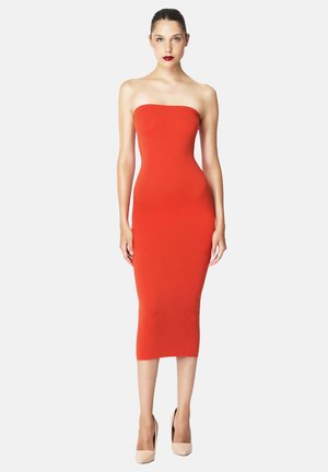 Rød stropløs midikjole i en tætsiddende silhuet, glat tekstur og sømløst design, parret med nude høje hæle.