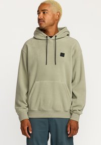 Hættetrøje i olivengrønt fleece med en frontlomme, ribbede manchetter og et lille sort logo-patch på brystet.