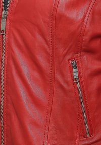 Rote Lederjacke mit glatter Textur, ausgestattet mit einem Reißverschluss vorne und einer Seitentasche. Die Nähte sind entlang der Kanten sichtbar.