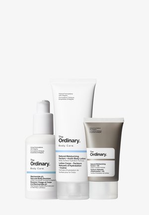 Three skincare products from The Ordinary: a clear glass bottle with a pump, a white tube, and a grey tube, all featuring simple labeling.