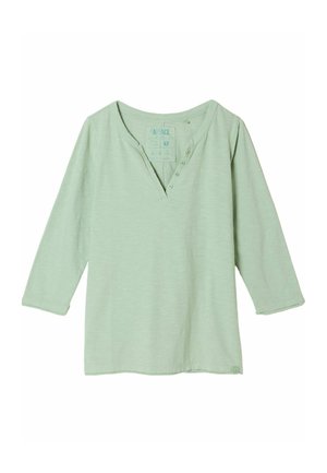 Hellgrünes Langarmhemd mit V-Ausschnitt und vier Knöpfen an der oberen linken Seite des Halsausschnitts, aus weichem Stoff gefertigt.