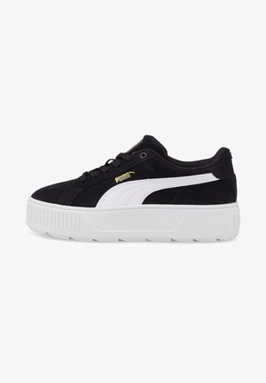 Zapatilla de ante negra con acentos blancos, que presenta una suela de plataforma y un logotipo dorado. Punta redonda, diseño con cordones y media suela texturizada.