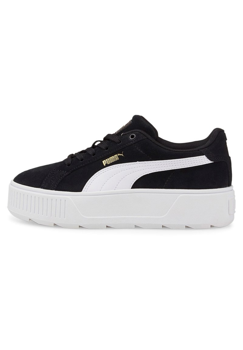 Zapatilla de ante negra con acentos blancos, que presenta una suela de plataforma y un logotipo dorado. Punta redonda, diseño con cordones y media suela texturizada.