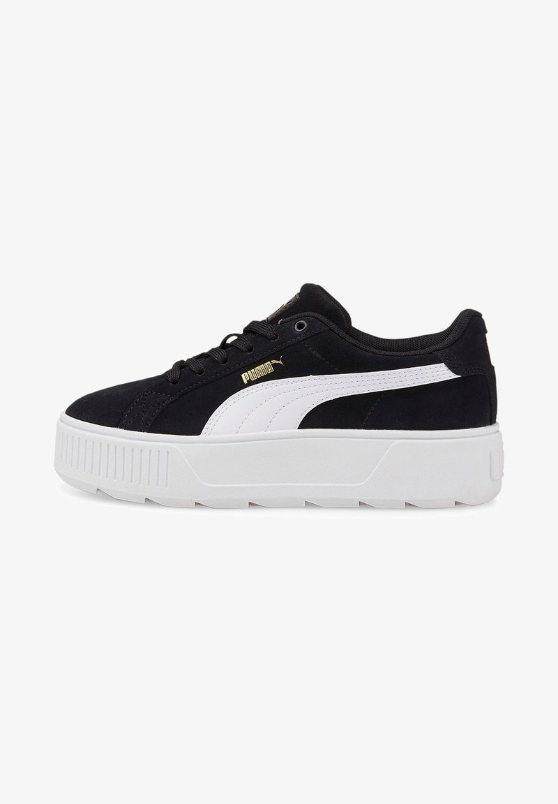 Zapatilla de ante negra con acentos blancos, que presenta una suela de plataforma y un logotipo dorado. Punta redonda, diseño con cordones y media suela texturizada.