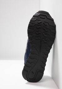 Námořnická sportovní bota s texturovanou černou gumovou podrážkou. Obsahuje hladký nubukový svršek a výrazný detail loga. Boční profil na bílém pozadí.