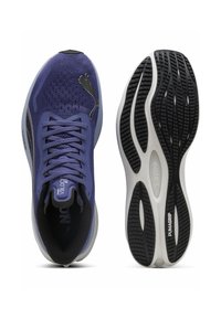 Violet tinkliniai sportiniai batai turi juodą vidų ir išskirtinę guminę jautriąsias dalis su zigzago raštu, užtikrinančiu sukibimą. Matomas PUMA logotipas.