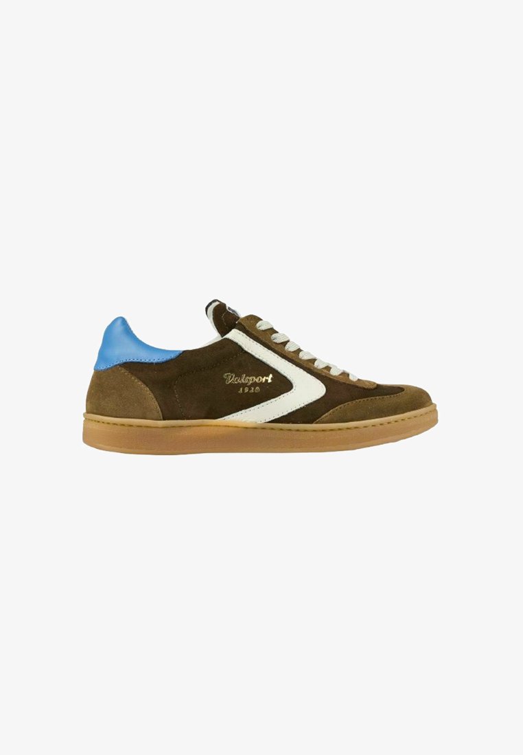 Zapatilla de ante marrón con un diseño de zigzag blanco y un acento en el talón azul. Presenta cordones grises y una suela de goma color beige. Estilo retro.