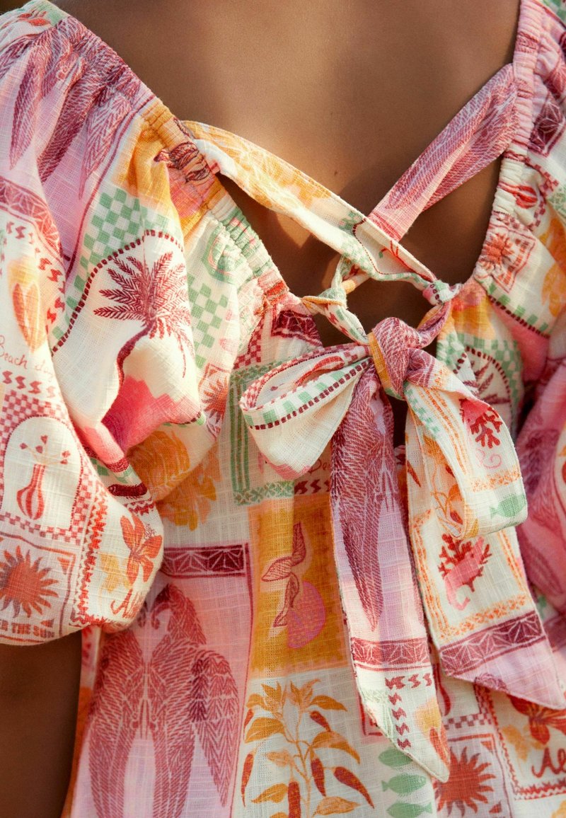 Multikleurige, lichte blouse met bloemen- en geometrische patronen, met pofmouwen en een gestrikt detail aan de achterkant.