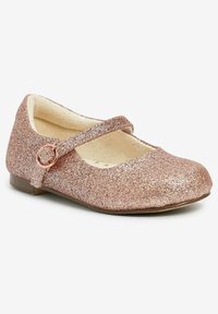 Różowo-złote brokatowe buty typu Mary Jane z okrągłym noskiem, regulowanym paskiem i niskim obcasem. Miękka wyściółka wewnętrzna i teksturowana powierzchnia.