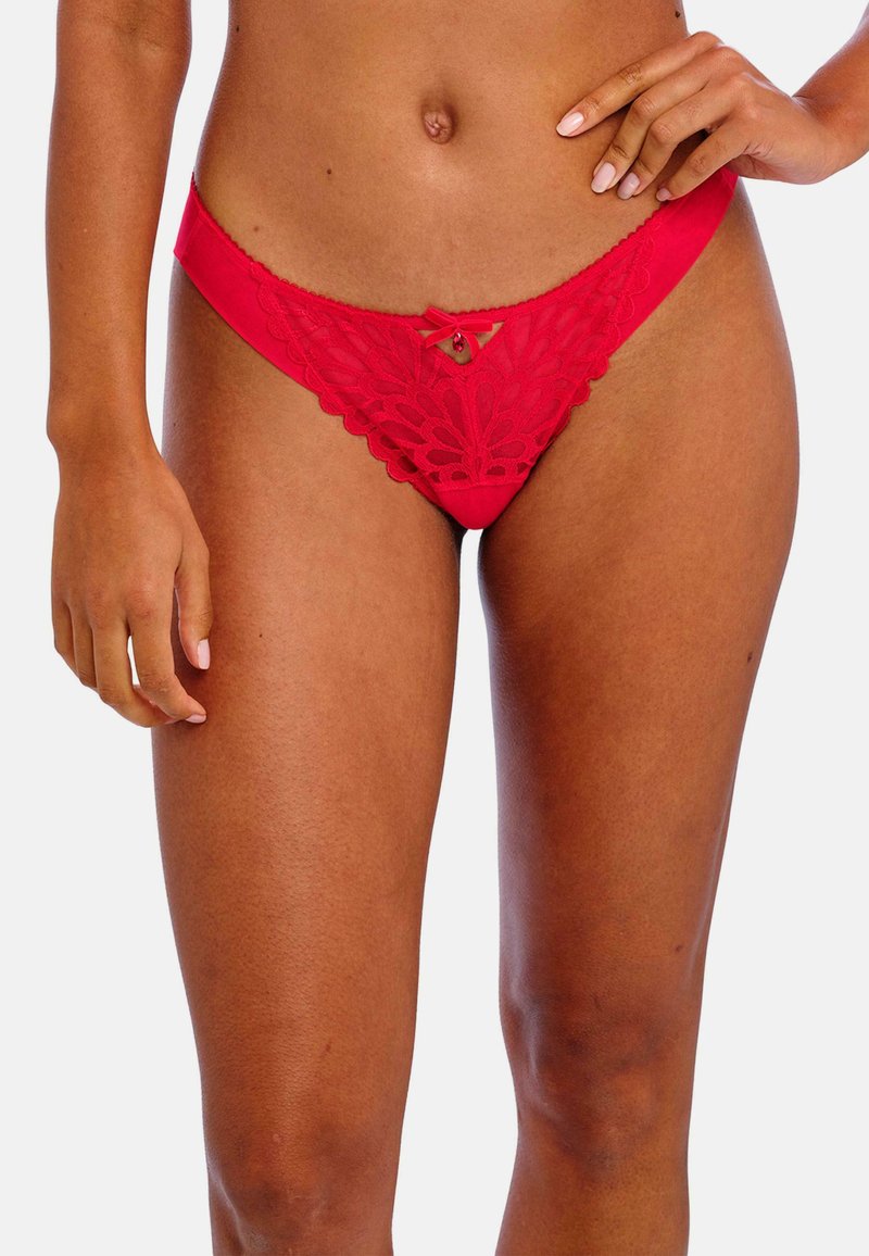 String rouge en dentelle avec un motif floral complexe, présentant un détail en nœud et un petit bijou. Matériau doux et coupe taille basse.