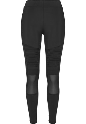 Leggings de sport noirs avec une texture lisse, dotés de panneaux côtelés et d'inserts en mesh sur le bas des jambes. Conception taille haute pour un meilleur maintien.