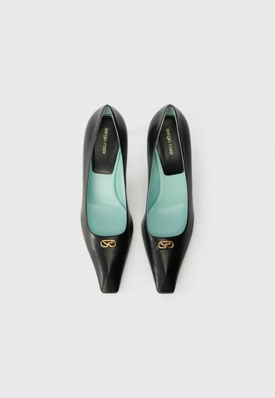 Czarny skórzany szpilki z czubkiem w szpic, kontrastującą miętową wkładką i złotym logo na zewnętrznej stronie.