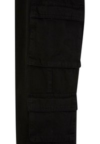 Pantalons cargo noirs en tissu durable, dotés de deux grandes poches latérales, d'un matériau texturé et de détails de coutures le long des coutures.