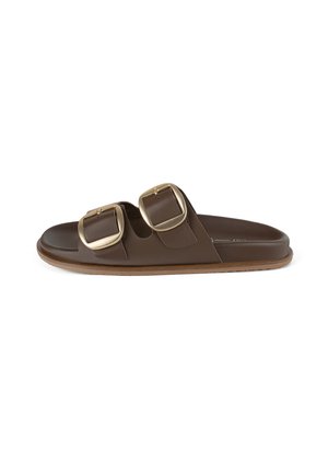 Bruine slippers met twee brede banden en grote gouden gespen. Glad leermateriaal, platte zool met lichte structuur, zonder zichtbare patronen.