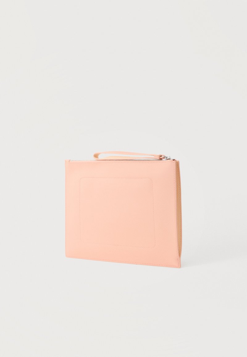 Rechthoekige lichtroze clutch met polsbandje en bovenste ritssluiting op een effen achtergrond.