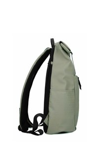 Sac à dos vert à rabat avec des accents noirs, en matériau imperméable, poche zippée sur le côté, motif texturé sur la partie inférieure, et bretelles réglables.