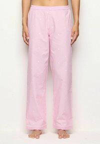 Roze pyjamabroek met witte stippen, elastische tailleband, rechte pijpdesign, gladde textuur en contrasterende bies langs de zoom.