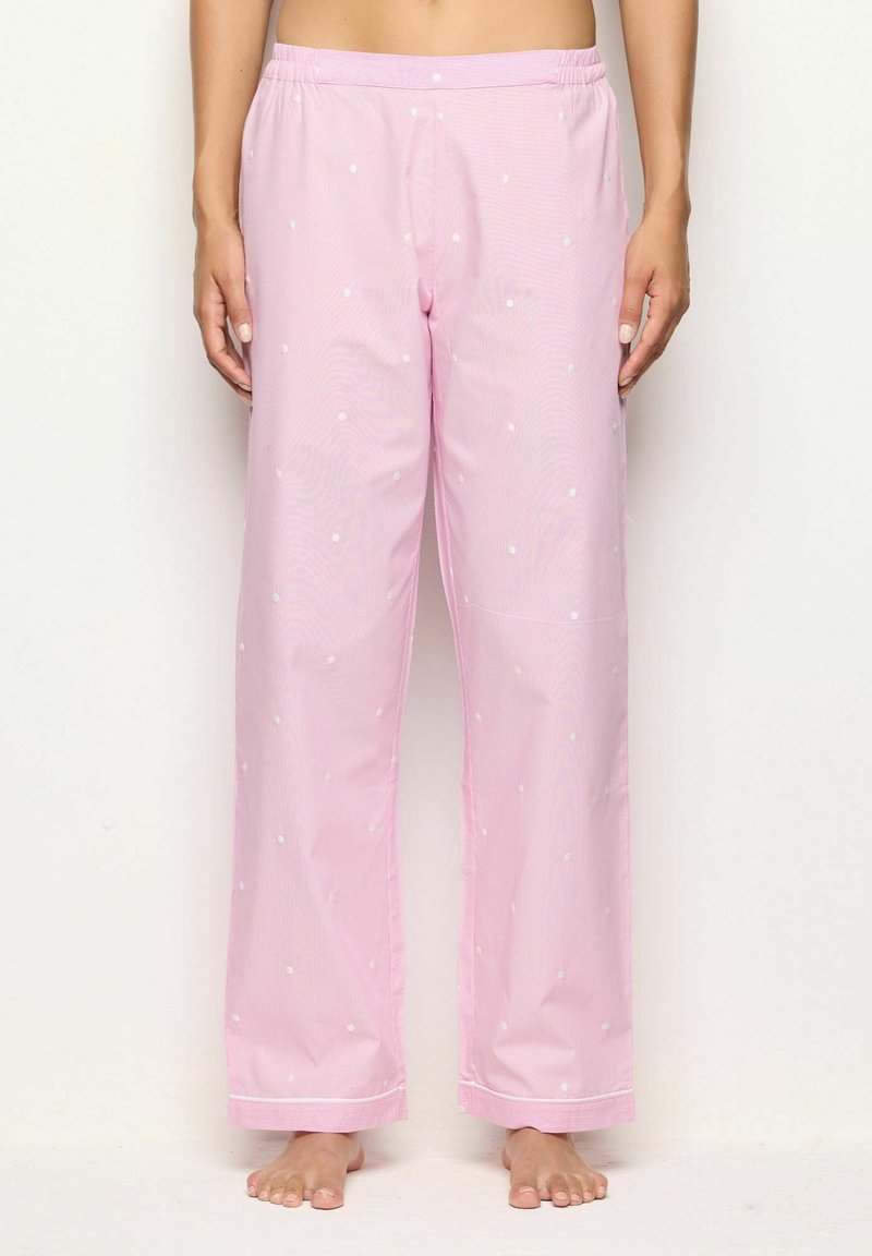 Roze pyjamabroek met witte stippen, elastische tailleband, rechte pijpdesign, gladde textuur en contrasterende bies langs de zoom.