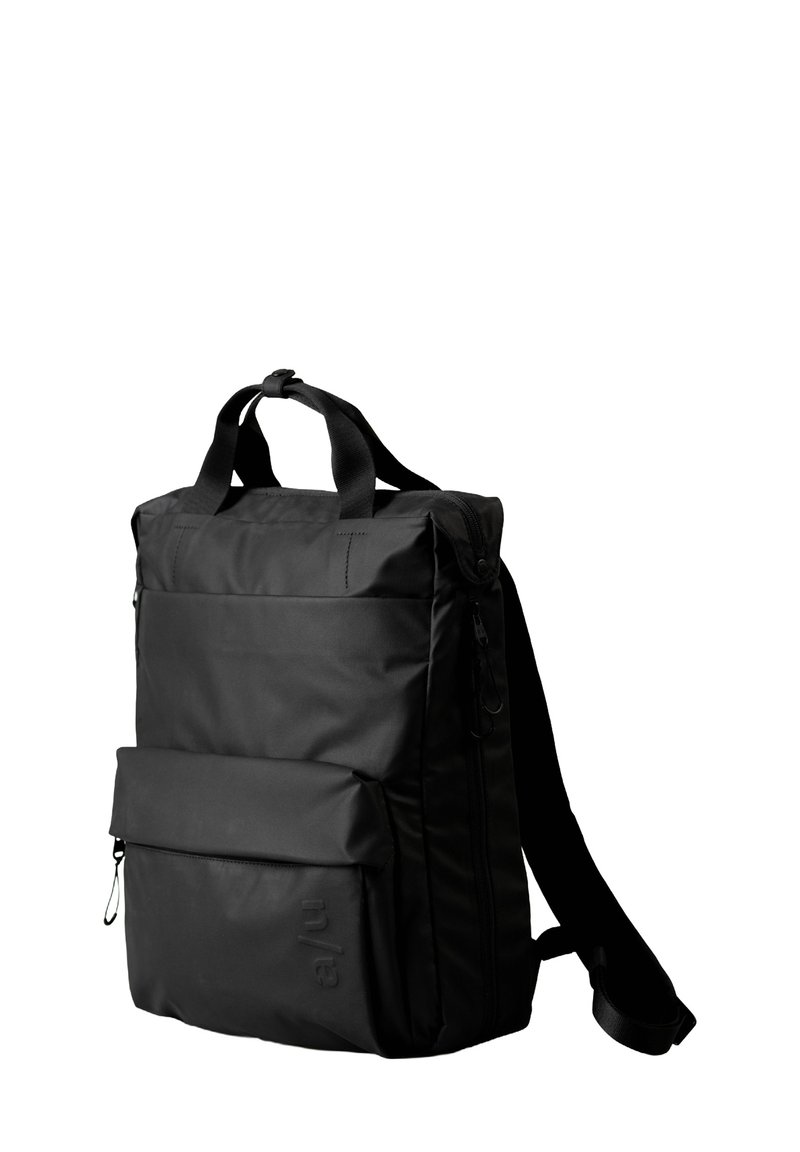 Zaino nero con forma rettangolare, tessuto resistente, maniglie superiori, una tasca anteriore con zipper e spallacci regolabili.
