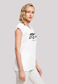 White cotton t-shirt with rolled sleeves, featuring a black printed text "HOW YOU DOIN'" and a curved line underneath. Simple design.
