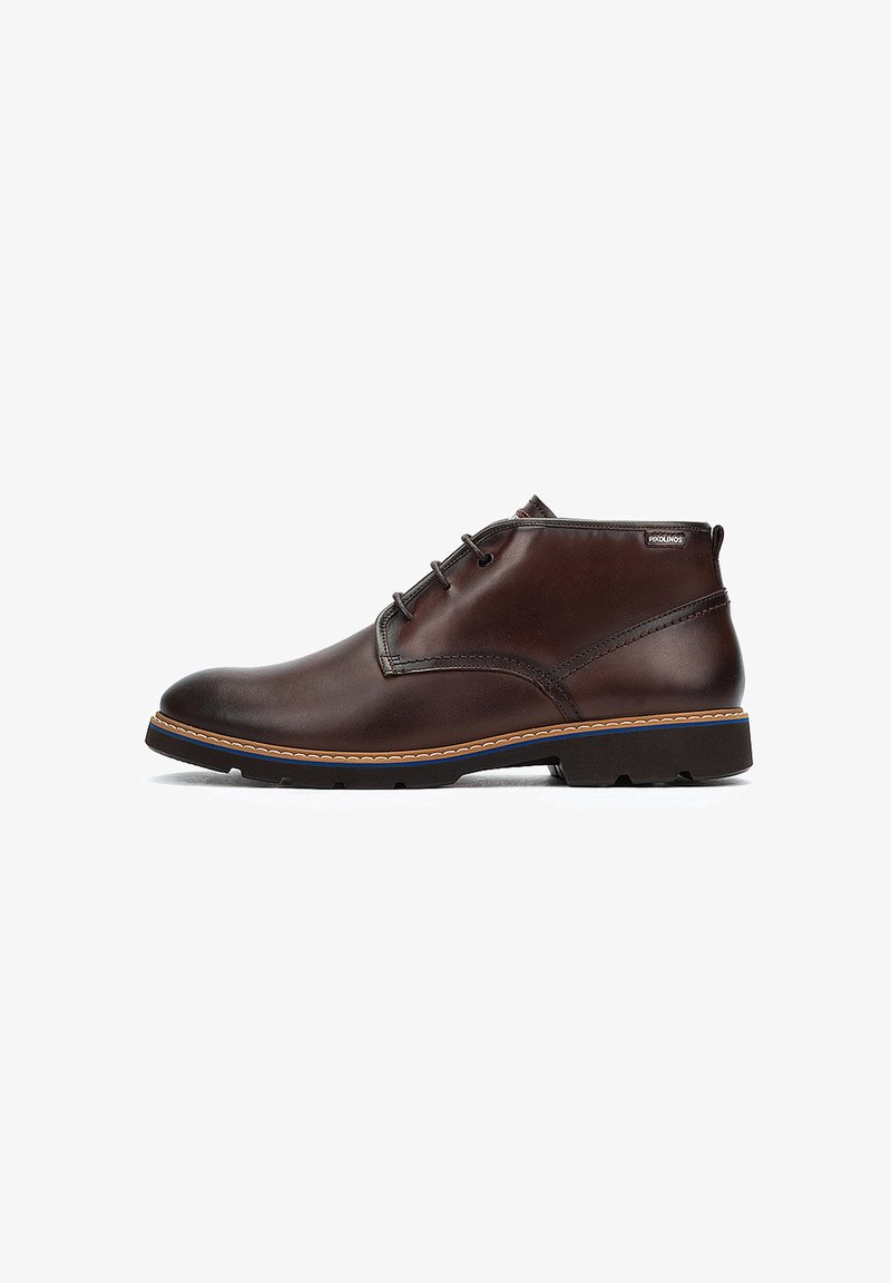Botas de cuero marrón hasta el tobillo con textura suave, puntera redonda, diseño de cordones con dos ojetes, costuras en contraste y una suela de goma duradera.