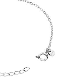 Zilveren schakelarmband met ovale schakel, voorzien van een ronde sluiting en een klein label. Spiegel het licht met een gladde, gepolijste textuur.