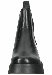 Stivali alla caviglia neri in pelle con un profilo elegante, pannelli laterali elasticizzati, una finitura testurizzata e una suola piatta in gomma. Nessun elemento metallico o motivo visibile.