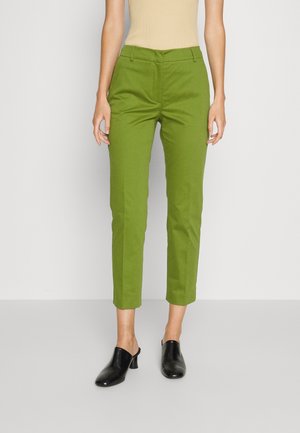 Groene cropped broek met een getailleerde pasvorm, voorzien van een soepele textuur en persplooien; gecombineerd met zwarte openteen muiltjes.