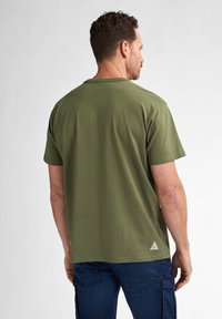 Olive green short-sleeve T-shirt made of cotton, featuring a crew neckline and a small logo patch at the lower left side.